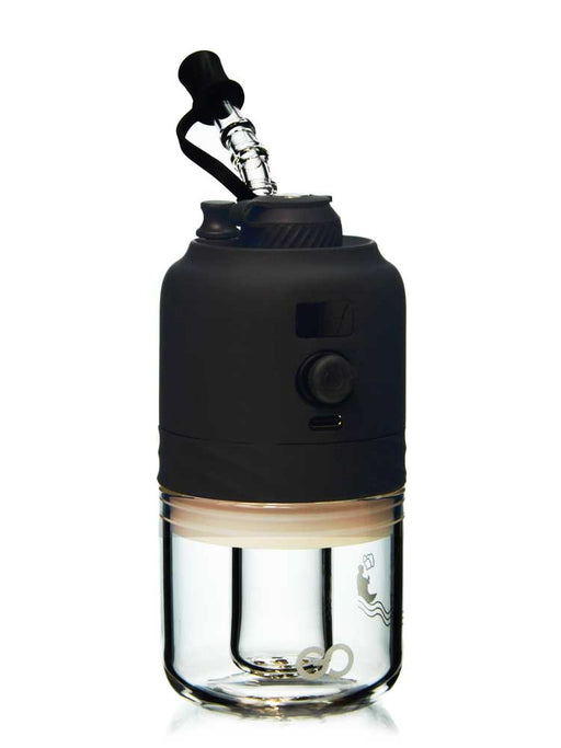 A portable electric dab rig with a matte black body and a clear glass container below, shown on a solid white background.